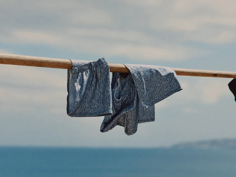 Short de bain homme imprimé suspendu à une corde en bois blanchi