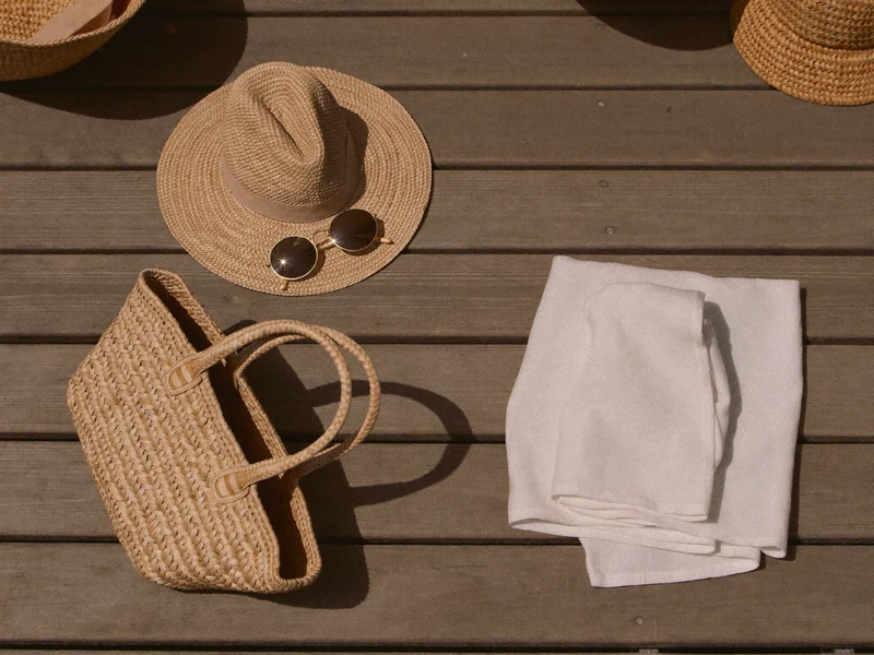 Accessoires de plage sans marque : chapeau de paille, lunettes, panier tressé et paréo